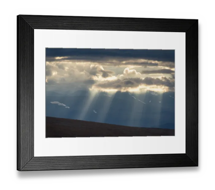 Framed Print : Sun rays fall through clouds in mountain landscape Framed Print : Sun rays fall through clouds in mountain landscape
