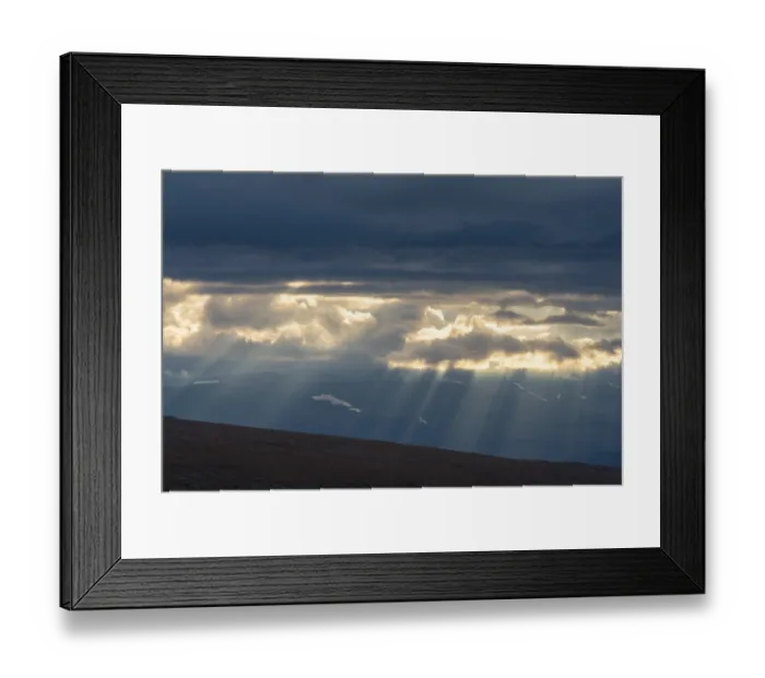 Framed Print : Sun rays fall through clouds in mountain landscape Framed Print : Sun rays fall through clouds in mountain landscape