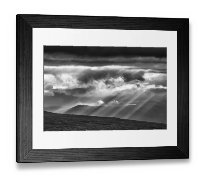 Framed Print : Sun rays fall through clouds in mountain landscape