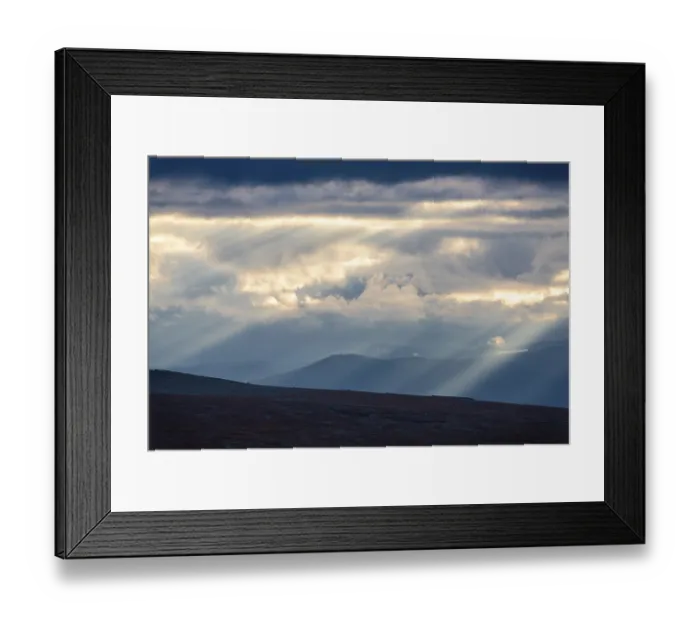 Framed Print : Sun rays fall through clouds in mountain landscape