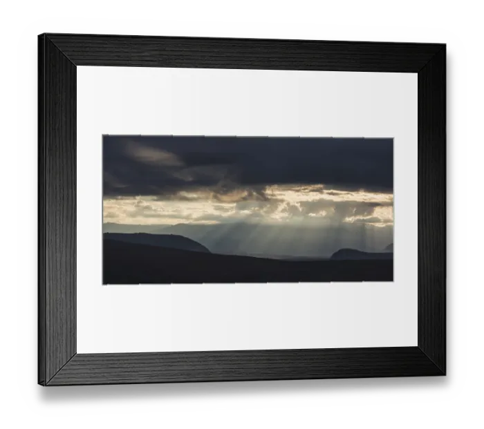 Framed Print : Sun rays fall through clouds in mountain landscape Framed Print : Sun rays fall through clouds in mountain landscape