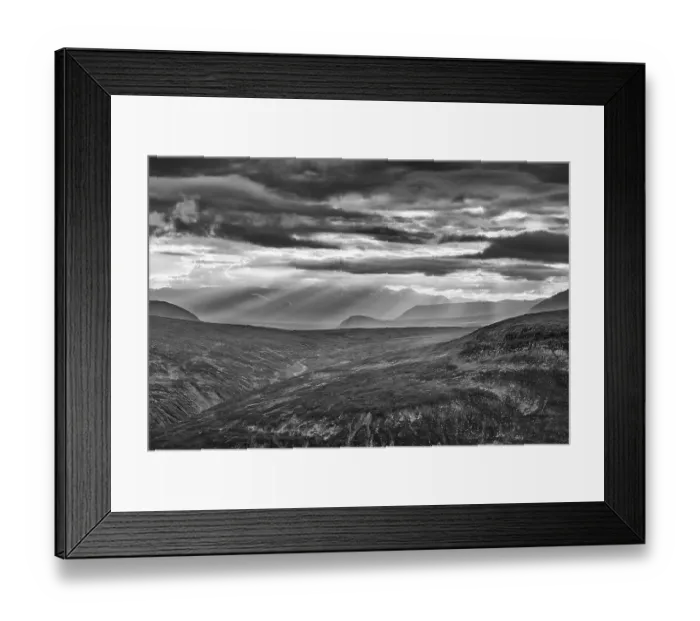 Framed Print : Sun rays fall through clouds in mountain landscape