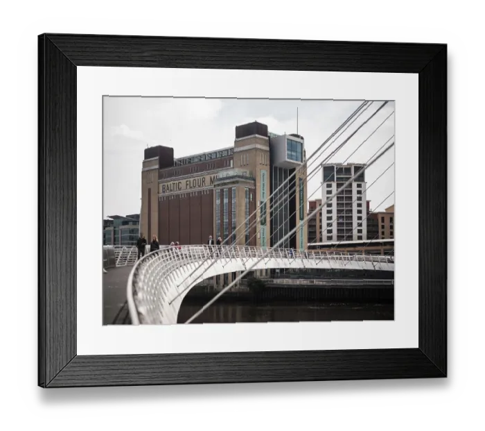 Framed Print : The Gateshead Millennium Bridge with a view of the Baltic Flour Mill and other city buildings in Newcastle Upon Tyne