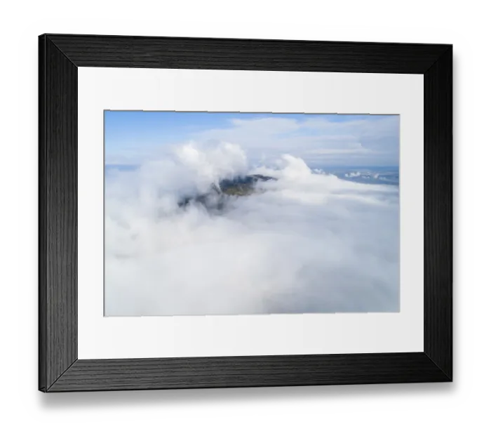 Framed Print : Dramatic view of mountains rising from clouds under blue sky