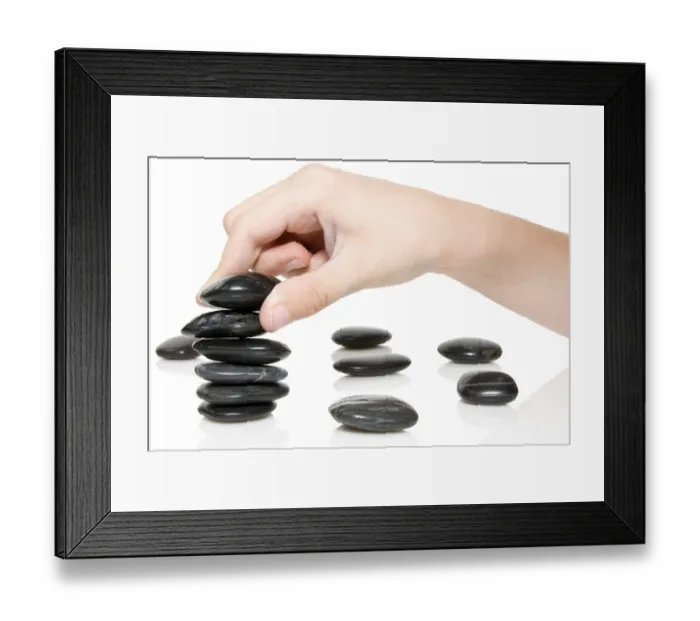 Framed Print : Building a Zen garden. hand and stones on white background