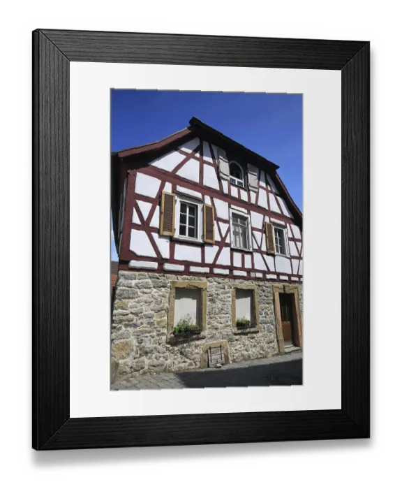 Framed Print : Small half-timbered house with red beams and stone foundation