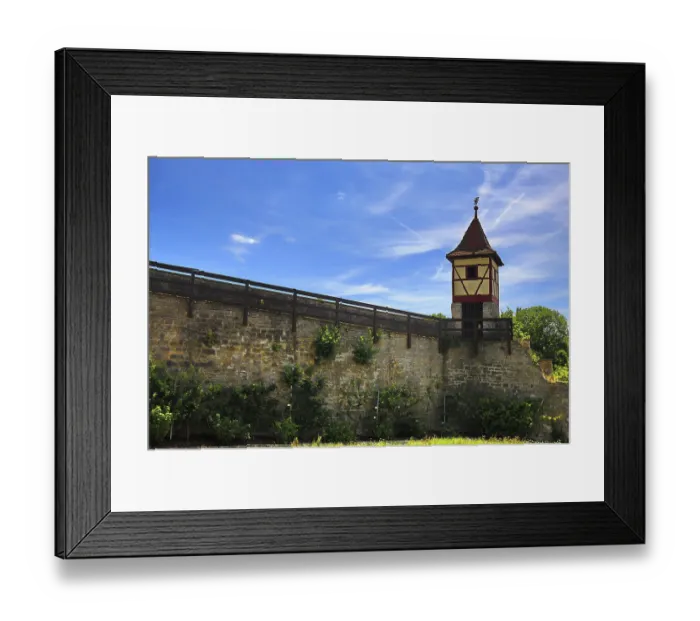 Framed Print : Half-timbered tower on high city wall under clear sky with surrounding greenery