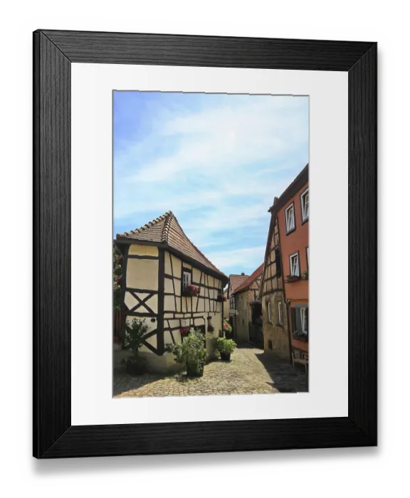 Framed Print : A narrow alley flanked by half-timbered houses