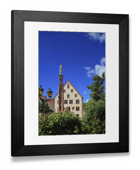 Framed Print : Historic building with statue and column surrounded by trees under blue sky