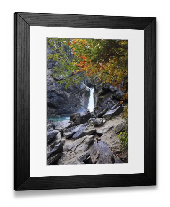 Framed Print : Waterfall surrounded by rocks and autumn trees