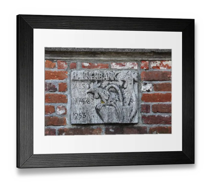 Framed Print : Historical stone relief with a rooster and inscription on a brick wall