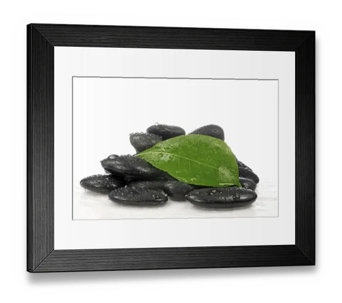 Framed Print : Pile of zen stones with a green leaf