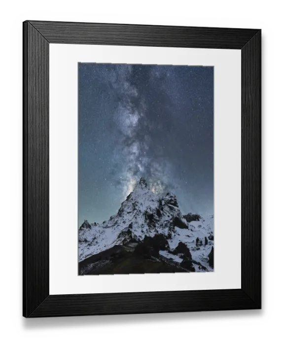 Framed Print : A spectacular view of the Milky Way illuminating the night sky over snow-covered peaks in Iceland