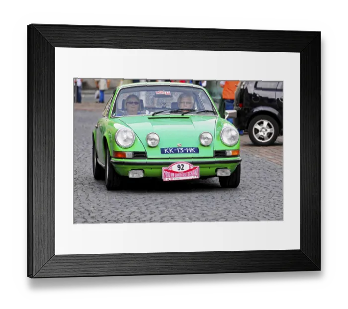 Framed Print : A green Porsche classic car drives on cobblestones through the city Framed Print : A green Porsche classic car drives on cobblestones through the city