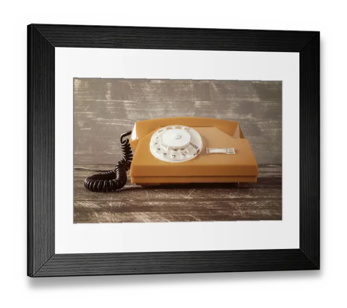 Framed Print : Old vintage classic telephone on wooden table