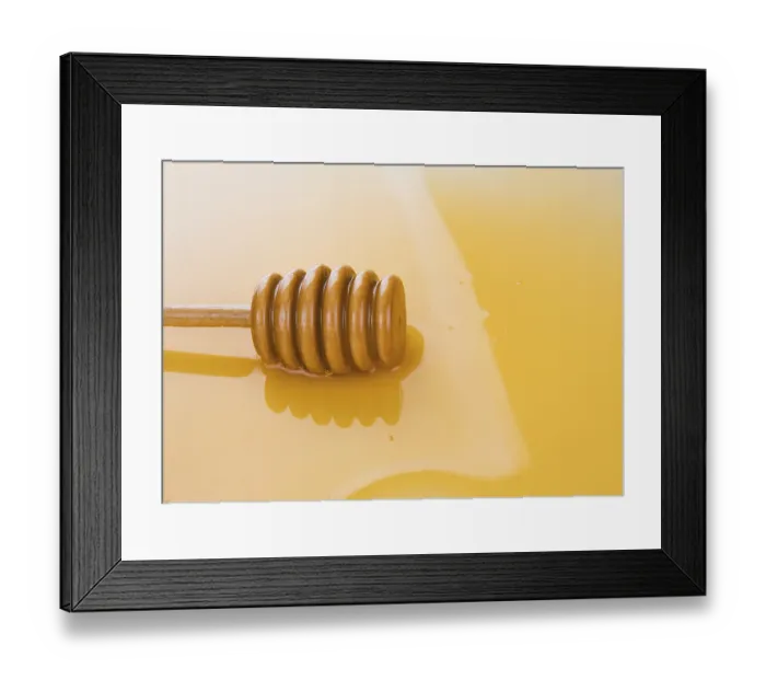 Framed Print : Puddle of honey with wooden stick as background