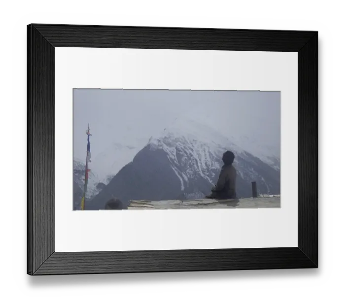 Framed Print : A person sits next to a Buddhist prayer flag on the roof of a house Framed Print : A person sits next to a Buddhist prayer flag on the roof of a house