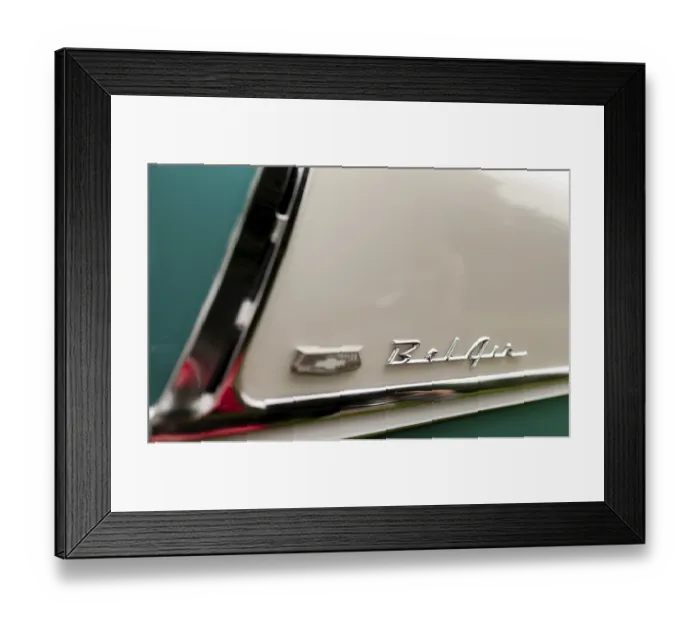 Framed Print : Close-up of a classic car emblem on a teal and cream colored body with chrome details in St