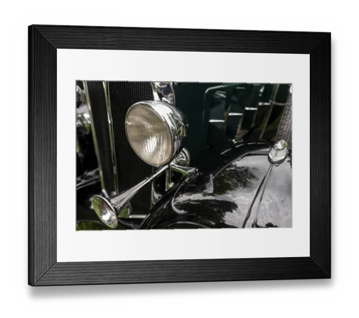 Framed Print : Close-up of a vintage green car's chrome horn and headlight with reflective elements in St