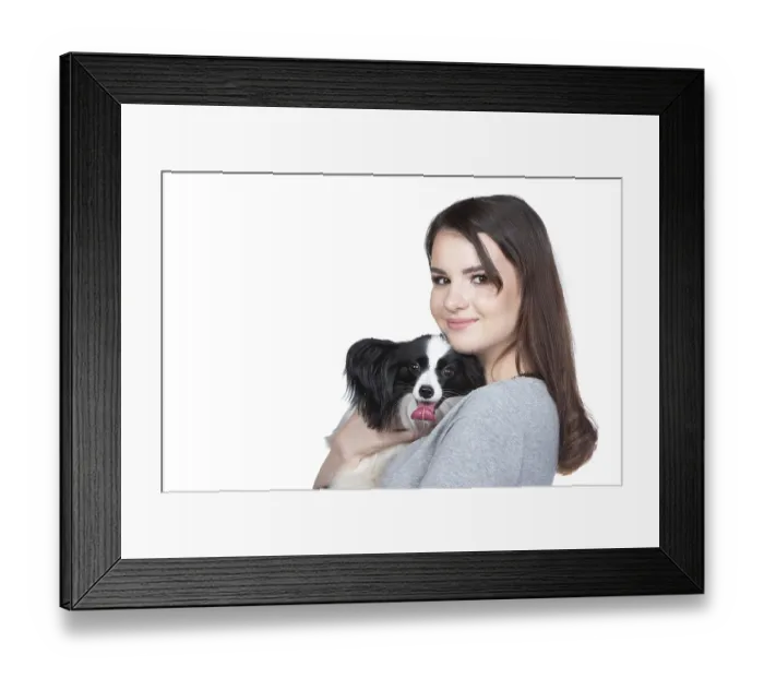 Framed Print : A lovely young woman is hugging her papillon puppy and looking into the cummera