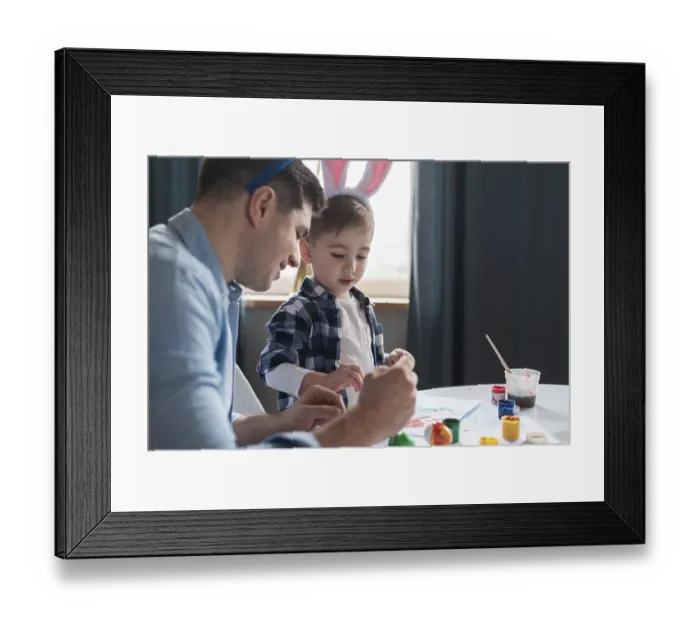 Framed Print : Father showing his son how paint easter eggs