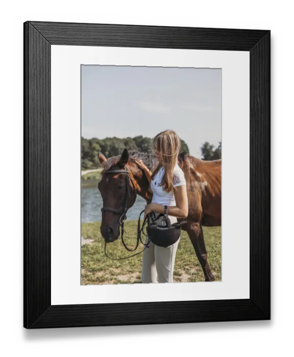 Framed Print : A young girl stands with her horse near a scenic lake