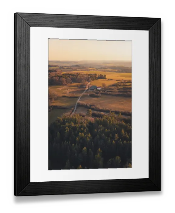 Framed Print : Fields and farm surrounded by forests at dusk