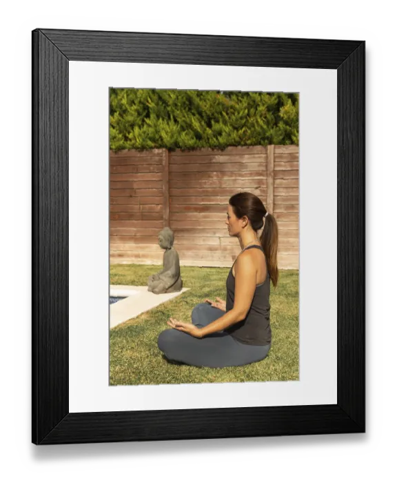 Framed Print : A woman in a casual workout outfit is engaged in the Sukhasana (Easy Pose)