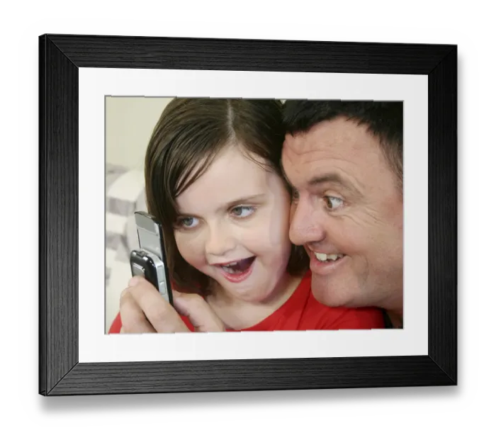Framed Print : Father and young daughter play a game on her cell phone Framed Print : Father and young daughter play a game on her cell phone