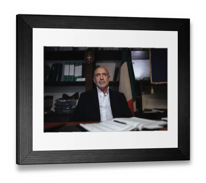 Framed Print : A confident business executive in formal attire sits at a desk in an office Framed Print : A confident business executive in formal attire sits at a desk in an office