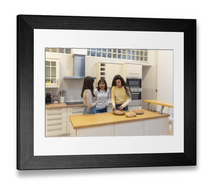 Framed Print : Three young women in a modern kitchen preparing homemade pizza