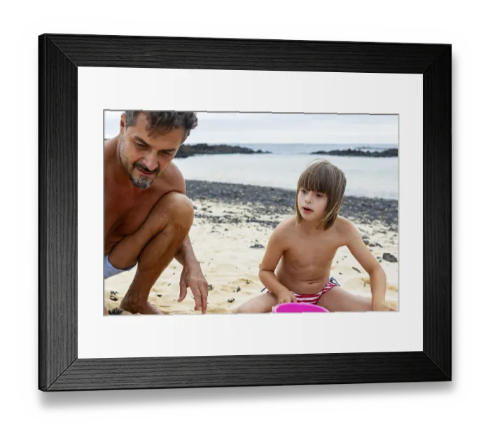 Framed Print : A joyful moment of a little girl with Down syndrome playing with her father on a sandy beach They are enjoying a sunny