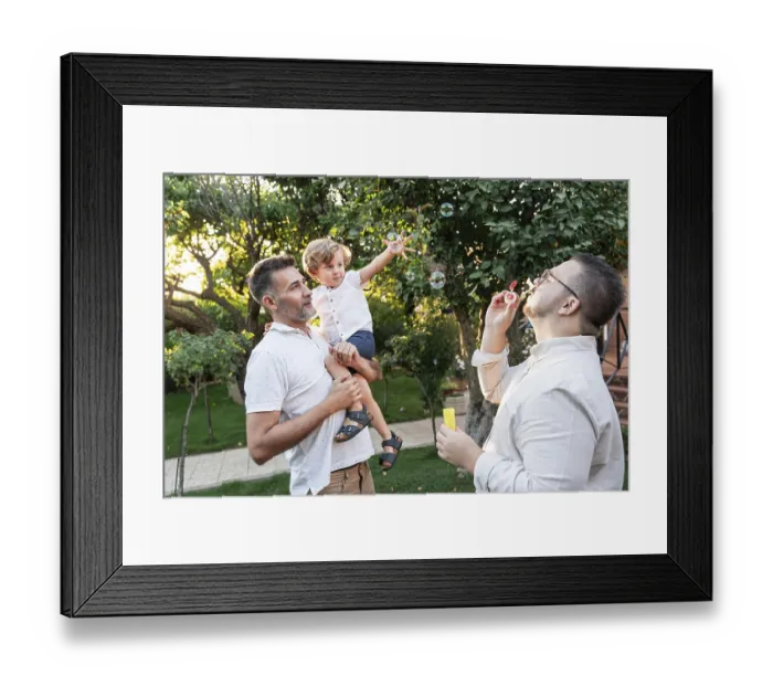 Framed Print : A joyful gay couple enjoys a sunny day in the garden with their young son