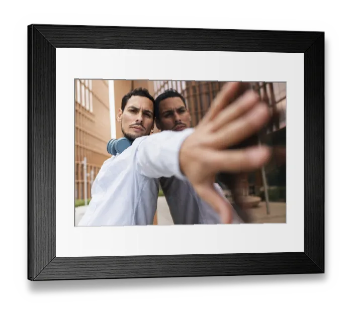 Framed Print : A Cuban man stands confidently in an urban setting with headphones around his neck Framed Print : A Cuban man stands confidently in an urban setting with headphones around his neck