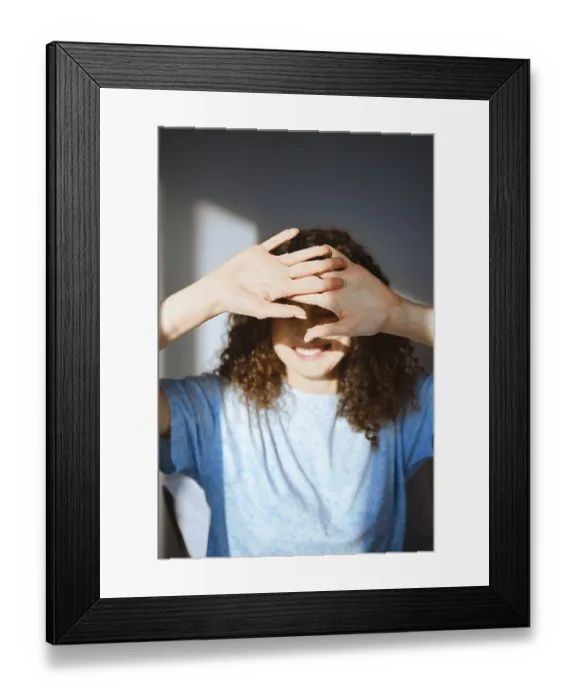 Framed Print : A woman stands in a well-lit room