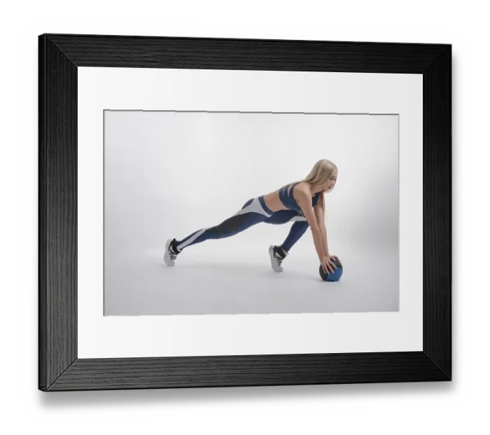 Framed Print : A woman showcases her beauty and athleticism with dynamic medicine ball exercises in a modern studio