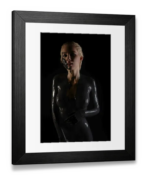 Framed Print : A woman stands confidently, her body adorned with glossy paint and tattoos
