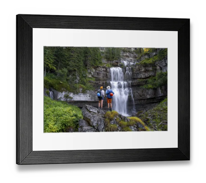 Framed Print : Young pretty hiker standing on rocks in front of Cascata di Mezzo waterfall