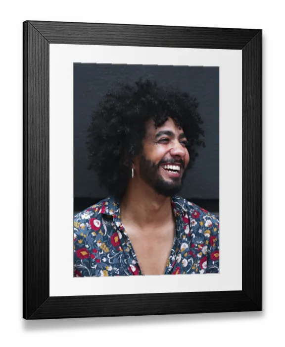 Framed Print : A smiling man with curly hair and a floral shirt exudes happiness Framed Print : A smiling man with curly hair and a floral shirt exudes happiness