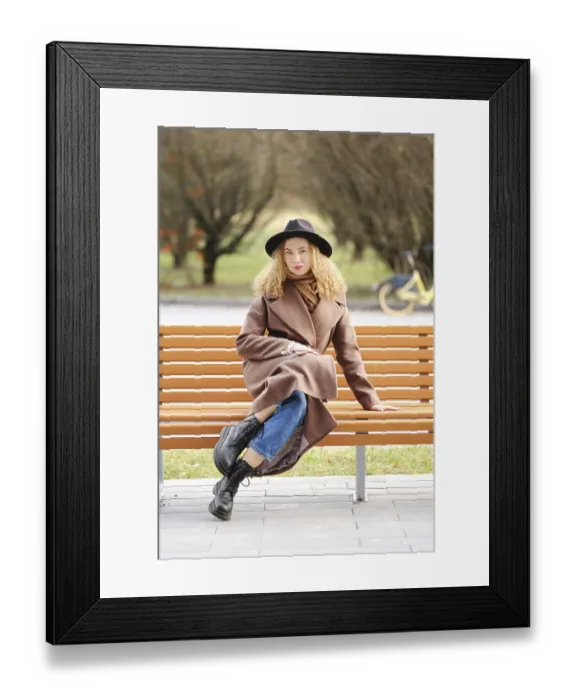 Framed Print : A woman sits on a wooden bench in a park Framed Print : A woman sits on a wooden bench in a park