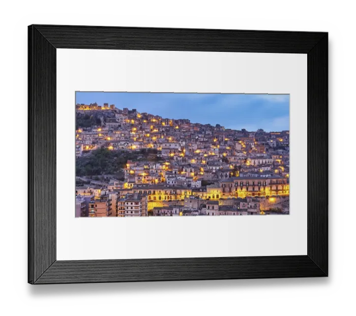 Framed Print : Modica, evening view of a mountainous urban landscape with illuminated houses