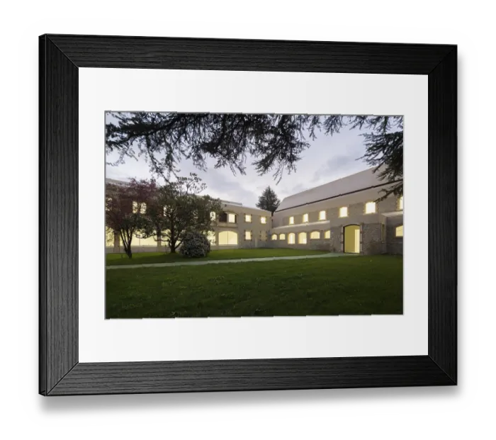 Framed Print : A serene evening scene showcases a historic stone hospital with glowing windows