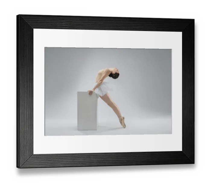 Framed Print : A graceful ballerina leans back elegantly while balancing on a sturdy block