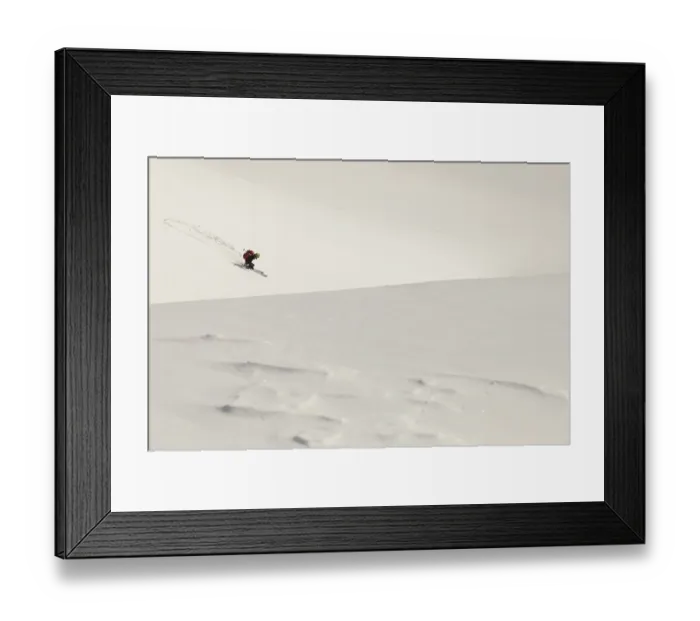 Framed Print : A skier descends a vast snow-covered mountain