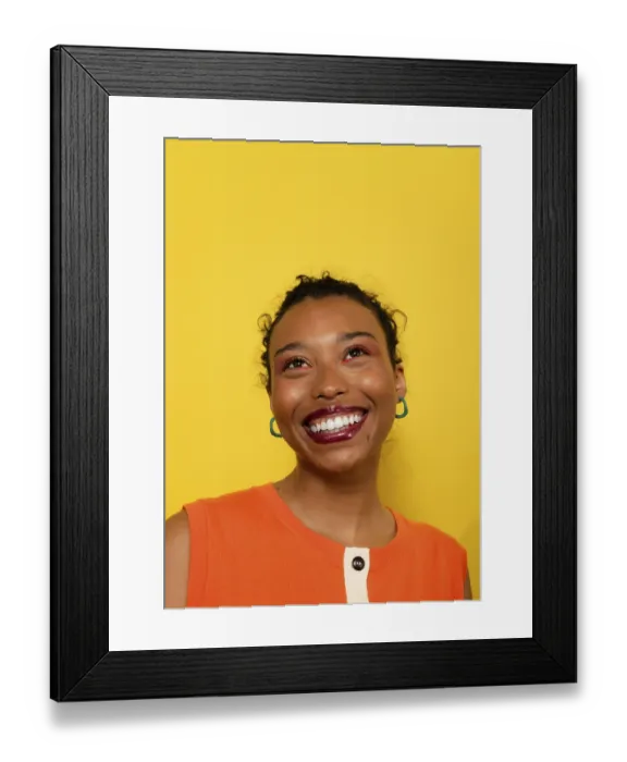 Framed Print : A joyful woman with a radiant smile looks upward against a bright yellow background