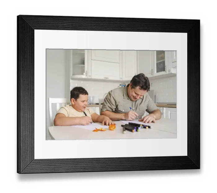 Framed Print : A father and son enjoy drawing together at the kitchen table