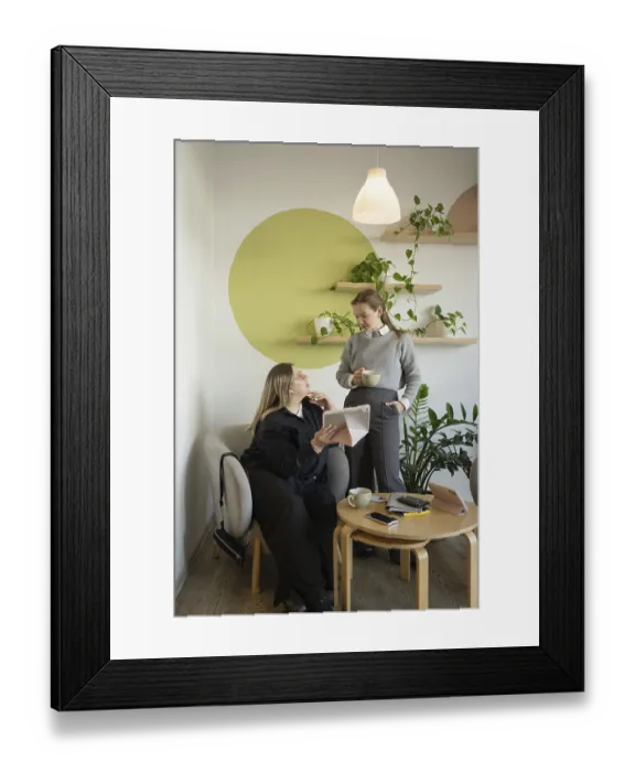 Framed Print : Two women engage in conversation in a cozy cafe setting