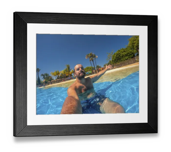 Framed Print : Bearded man with outstretched arm enjoying a refreshing bath in a wave pool at a water park