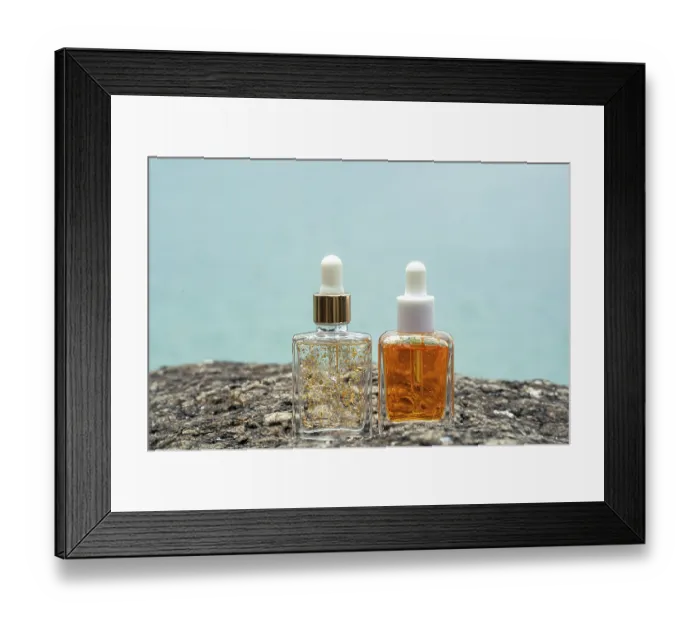 Framed Print : Two luxurious cosmetic serum bottles with golden flakes and vitamins
