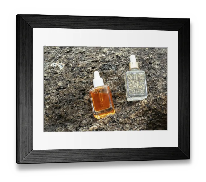 Framed Print : From above, two cosmetic serums enriched with vitamins and golden flakes rest on a rugged